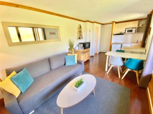 sala de estar con sofá y mesa en SUPER-BESSE Charmant T2 Piscine chauffée & Parking couvert, en Besse-et-Saint-Anastaise