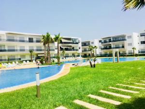 un complejo con piscina, playa y edificios en Appartement Blanca Beach, en Sidi Rahal