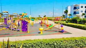 a playground at a park with a roller coaster at Appartement Blanca Beach in Sidi Rahal