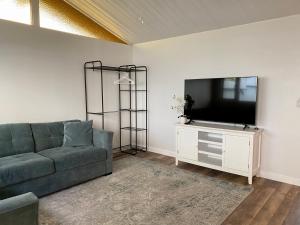a living room with a couch and a flat screen tv at Hawaii Getaway in Holualoa