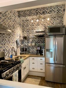 cocina con nevera de acero inoxidable y azulejos en Hawaii Getaway, en Holualoa