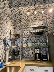 cocina con fregadero y pared de azulejos en Hawaii Getaway, en Holualoa