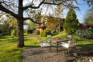 einen Tisch und Stühle unter einem Baum im Hof in der Unterkunft Apartment Villa Ema in Krapinske Toplice