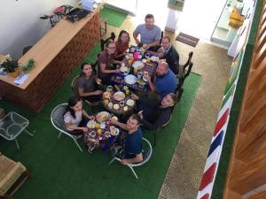 a group of people sitting around a table with food at Hostal Mendieta in Paracas