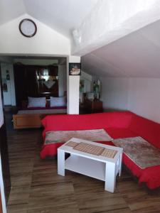 Sala de estar con cama roja y mesa en GM - Studio Apartment, en Trebinje