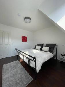 a bedroom with a bed with white sheets and black pillows at Ferienhaus Esten's Eifelheimat Wehr Eifel in Wehr