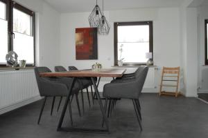 a dining room with a wooden table and chairs at Ferienhaus Esten's Eifelheimat Wehr Eifel in Wehr