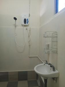 a white bathroom with a sink and a shower at Juara Cottage in Tioman Island