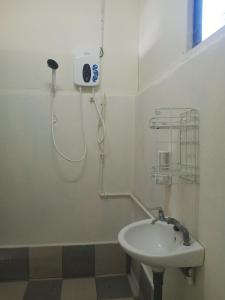 Un baño blanco con lavabo y ducha. en Juara Cottage, en Tioman Island