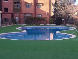 a swimming pool in front of a building at Confortable y luminoso apartamento in Valladolid