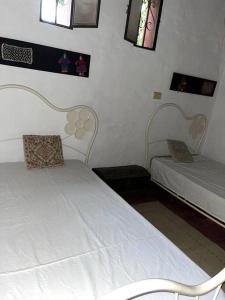 a bedroom with two beds and two windows at Casa de Huéspedes La Escondida in Yerba Buena