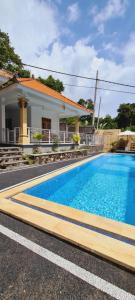 a swimming pool in front of a house at HOME VILLA in Pabean Buleleng