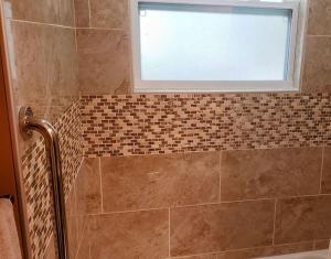 uma casa de banho com um chuveiro e uma janela em Stylish Suite Tampa Minutes to Hard Rock Casino em Tampa