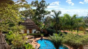 a swimming pool in a resort with people in it at Banda Lodge in Masaka