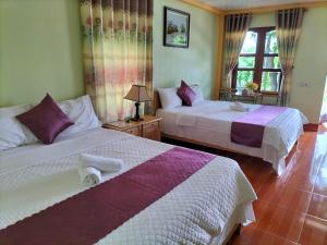 um quarto com 2 camas e uma janela em Tam Coc Rice Fields Homestay em Ninh Binh