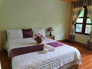 - une chambre avec un lit, des serviettes et des fleurs dans l'établissement Tam Coc Rice Fields Homestay, à Ninh Binh