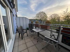 a balcony with chairs and a table on a building at Maisonette Penthouse für 8 Personen by Rabe - free Netflix & kostenloser Parkplatz & große Terrasse in Karlsruhe