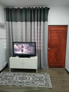 - un salon avec une télévision et une porte dans l'établissement DARUL AMAN Homestay Jitra, à Jitra
