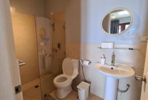 a bathroom with a toilet, sink, and mirror at Reef Beach Resort in General Luna