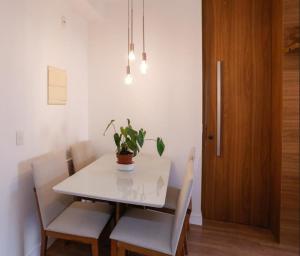 Apartamento inteiro para hospedagem في ساو باولو: طاولة غرفة الطعام مع نبات خزاف عليها