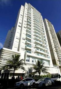 Apartamento inteiro para hospedagem في ساو باولو: مبنى أبيض طويل وبه سيارات متوقفة أمامه