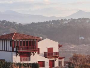 una casa bianca con balconi rossi e una montagna di Appartement de caractère avec balcon et parking à 2 pas de la plage, centre historique de Saint-Jean-de-Luz - FR-1-4-577 a Saint-Jean-de-Luz Altre 12 foto