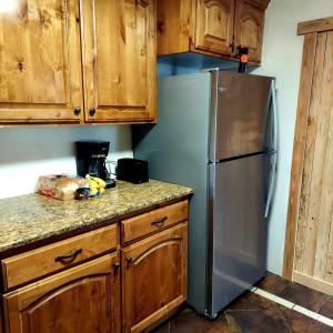 a kitchen with a stainless steel refrigerator and wooden cabinets at Vintage Cozy Family Home near National Parks in Saint Anthony