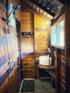 een badkamer met een wastafel in een houten huisje bij La Maison - Chiangmai in Mae Taeng