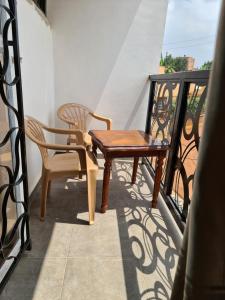 stół i 2 krzesła na balkonie w obiekcie Unia fancy flats studio Apartment one w mieście Kampala