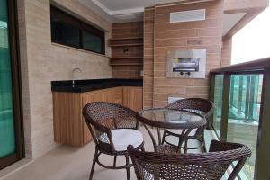 una cocina con tres sillas y una mesa con fregadero en Apê dos Anjos, en Arraial do Cabo