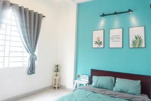 a bedroom with a blue wall with pictures on the wall at Gikgo Can Tho in Can Tho