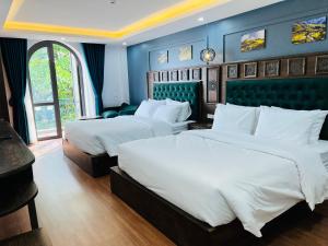 two beds in a room with blue walls at Sapa Grand Hills Hotel Apartments in Sa Pa