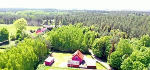 an aerial view of a red barn in a forest at Domek letniskowy w lesie 6 -7 osób in Wydminy