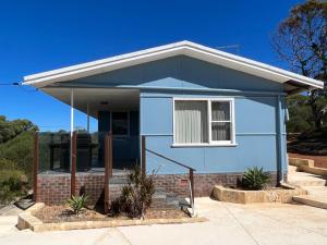 een blauw huis met een raam op een straat bij River Panorama Beach House in Guilderton