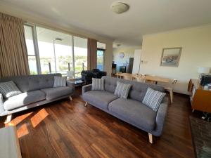 een woonkamer met twee banken en een tafel bij River Panorama Beach House in Guilderton