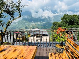 a wooden table on a balcony with a view of a mountain at Sapa Grand Hills Hotel Apartments in Sa Pa