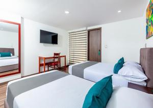 a hotel room with two beds and a television at Hotel Basan Plaza in Pasto