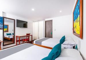 帕斯托Hotel Basan Plaza的有两张床和一张书桌的酒店房间