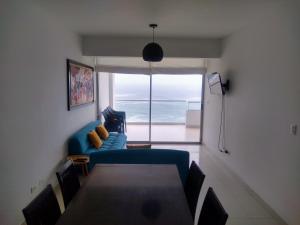 ein Wohnzimmer mit einem blauen Sofa und einem Tisch in der Unterkunft Departamento en Punta Hermosa con Vista al Mar in Punta Hermosa