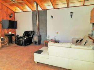 uma sala de estar com um sofá branco e uma lareira em Casona Campestre Santa Filomena em Granizo