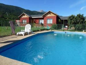 uma piscina com duas cadeiras e uma casa em Casona Campestre Santa Filomena em Granizo