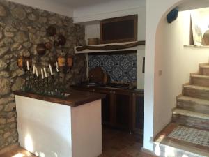 a kitchen with a stone wall with a counter and stairs at Casa Capri Sunset in Anacapri