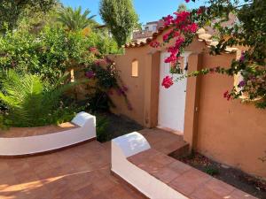 um jardim com flores cor-de-rosa num edifício em ALLE VIGNE CASE VACANZE em Vulcano