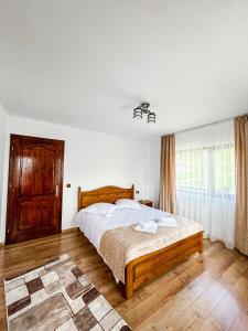 a bedroom with a bed and a large window at Casa BiaFlor in Rucăr