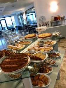 a buffet with many different types of pies and pastries at Hotel Tritone Rimini in Rimini