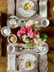 una mesa con platos y flores. en Piccola Corte Antica, en Corticelle Pieve