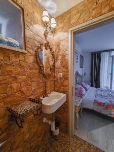 a stone walled bathroom with a sink and a bed at Kaya house in Nerežišća