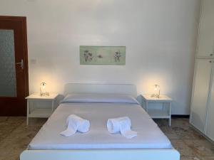 sypialnia z łóżkiem z dwoma stolikami bocznymi w obiekcie Casa Vacanza! A 50m dal mare! w mieście Bordighera
