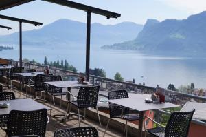 a restaurant with tables and chairs and a view of a lake at Hotel Roggerli in Hergiswil