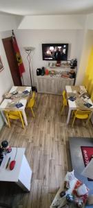 un soggiorno con tavoli, sedie e TV di B&B AKROPOLIS a Taormina